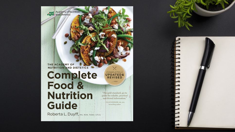 Copy of Complete Food & Nutrition Guide, 5th Ed. lying on a desk.
