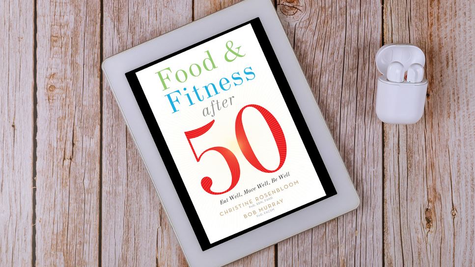 Food & Fitness After 50: Eat Well, Move Well, Be Well on a tablet screen, with the tablet lying on a desk.