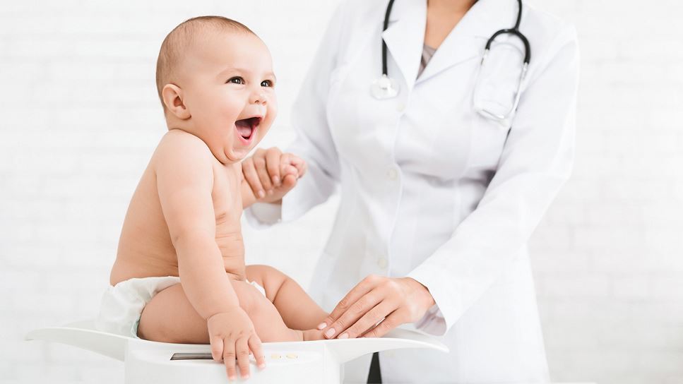 Baby on table with doctor.