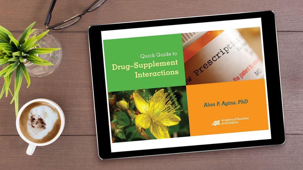 Quick Guide to Drug-Supplement Interactions on a tablet screen, with the tablet lying on a desk.