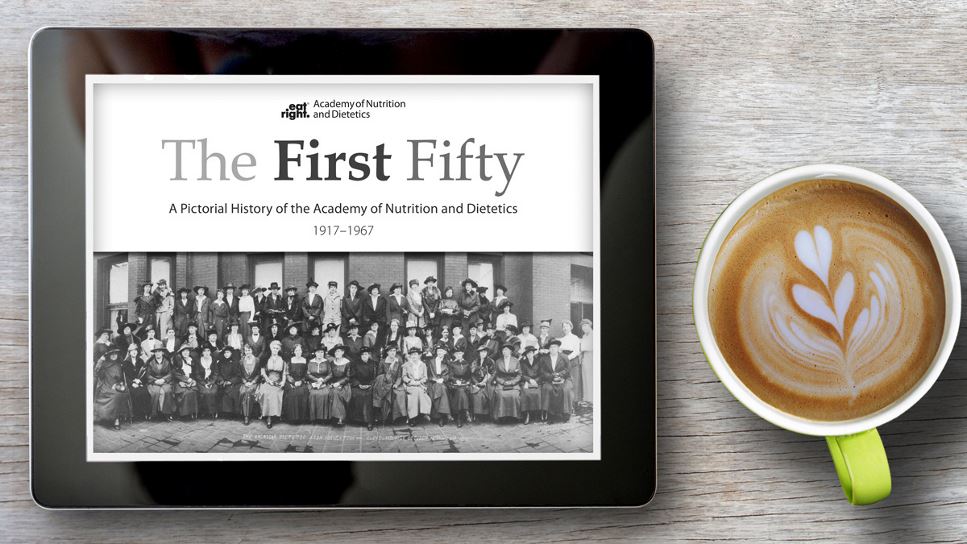 The First Fifty: A Pictorial History of the Academy of Nutrition and Dietetics on a tablet screen, with the tablet lying on a desk.