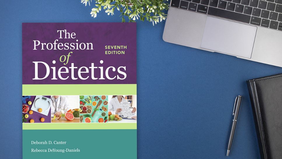 Copy of The Profession of Dietetics, 7th Ed. lying on a desk.