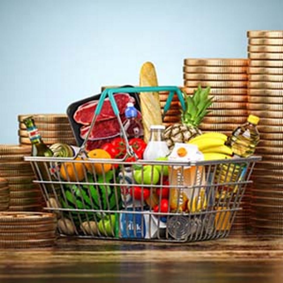 Giant gold coins in stacks of different sizes placed around a wire shopping basket.